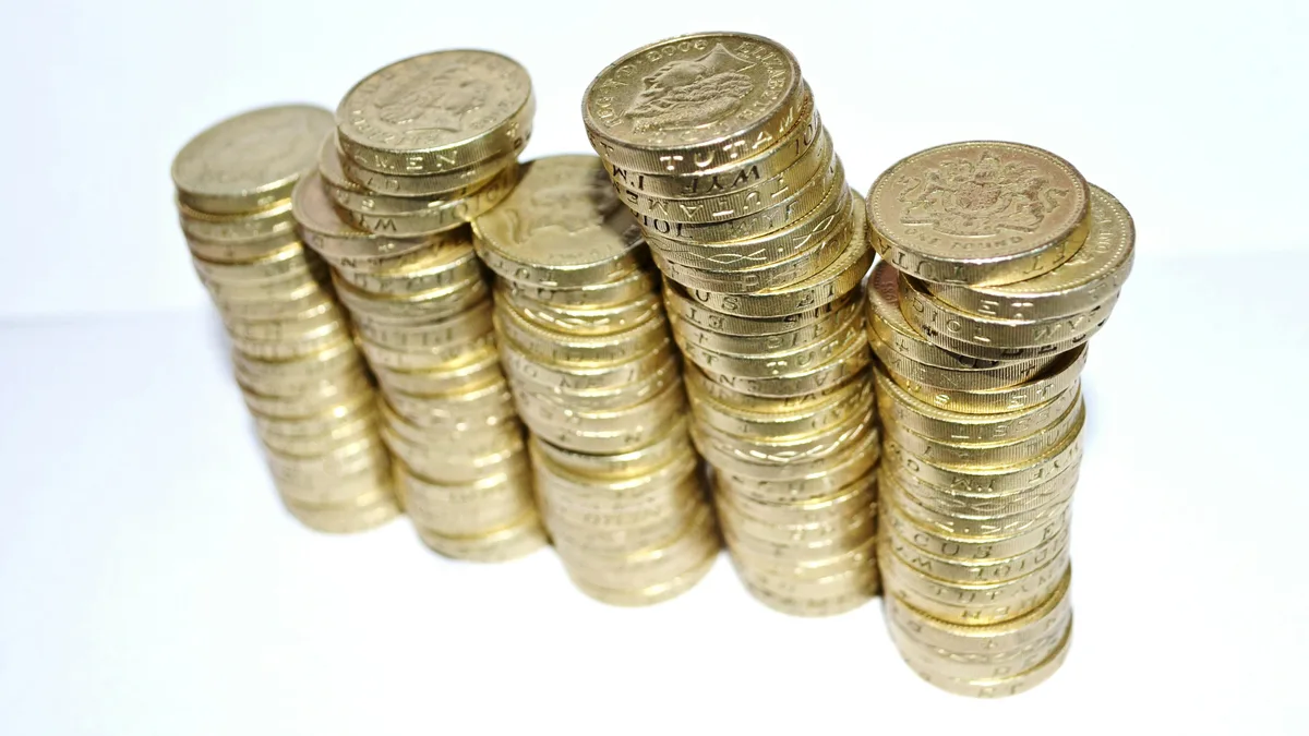 Le DCA (investissement programmé) expliqué par l'exemple A stack of coins growing taller, a fixed sum invested at regular intervals buys more shares when prices are low and fewer when they are high